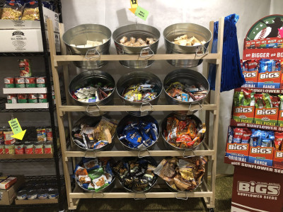 A rack of metal buckets, each containing small bags of snacks.