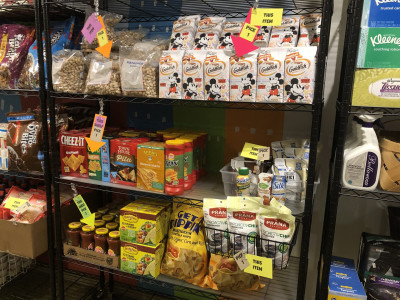Shelves of grocery items including cookies, crackers, snacks and salsa.